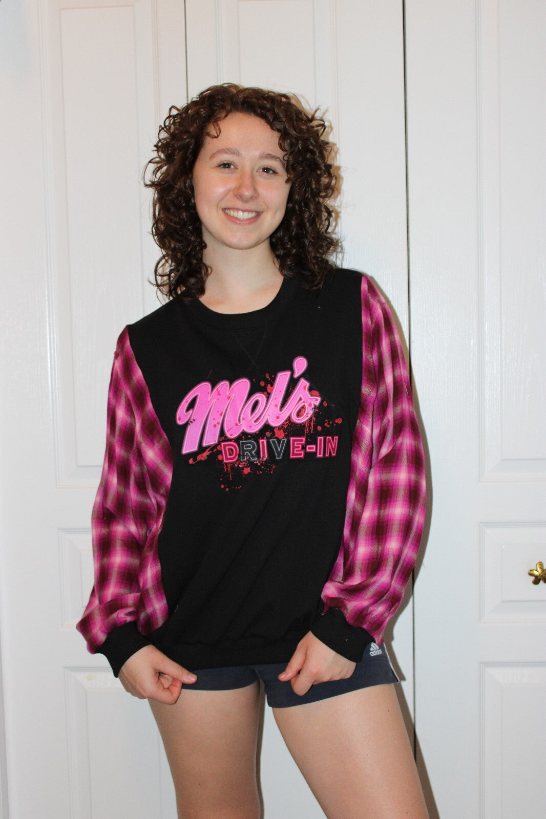 HHN Mel's DIVE-In Black Sweatshirt with Pink Plaid Sleeves and Graphic Print, Size Medium (TTS)